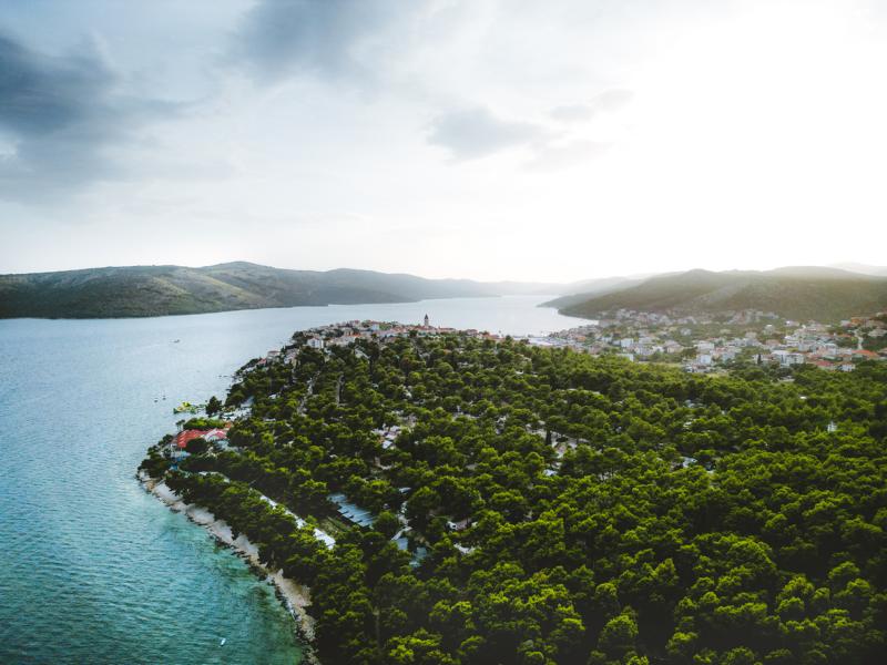 Meer und Wald und Ort mit Kirche in Kroatien thealkamalsontheroad