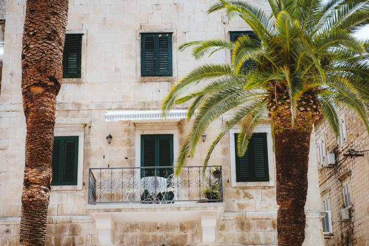 Haus mit altem Balkon und Palmen Makarska Kroatien thealkamalsontheroad