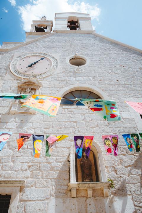 Fahnen vor einer Kirche in Sibenik Kroatien thealkamalsontheroad