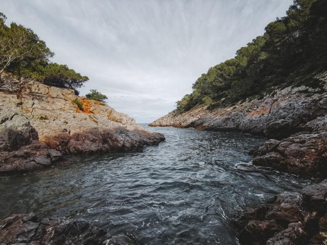 Cala Pedrosa Wasser mit felsigen Hängen Spanien thealkamalsontheroad