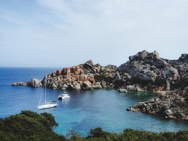 Boote vor dem Capo Testa im Meer Sardinien thealkamalsontheroad