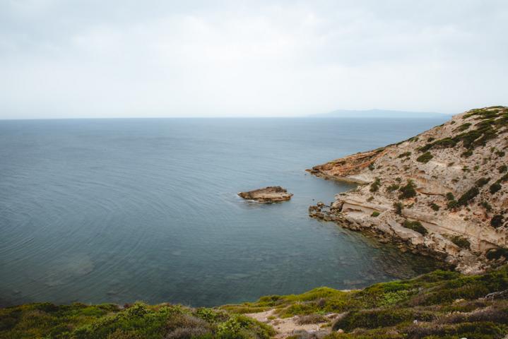 Capu Mannu Steine und Felsen vor dem Meer und grüner Macchia Sardinien thealkamalsontheroad