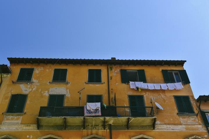 gelbes Haus auf Elba mit grünen Fensterläden Italien thealkamalsontheroad