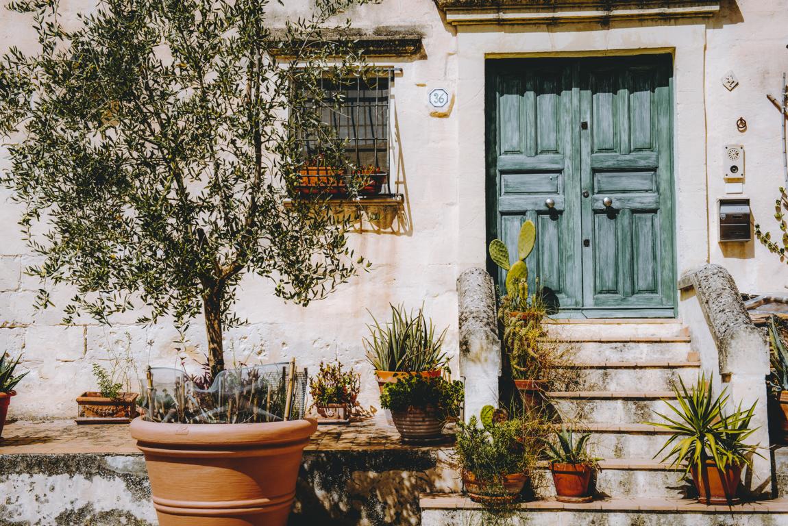 matera-italien-thealkamalsontheroad (3) blaue Haustüre mit Baum und Pflanzen in Matera