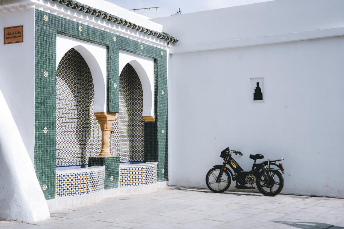 Brunnen mit Mosaiken und Moped